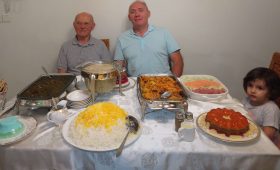 deux hommes derriere une table avec des plats